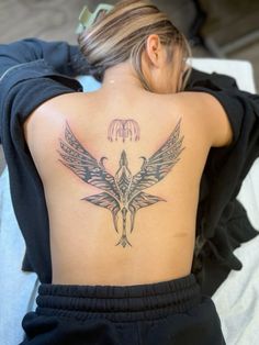 a woman with a bird tattoo on her back