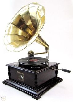 an old phonograph on top of a record player with its horn up in the air