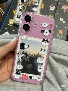 someone is holding up their phone case with cats on it and other stickers in the background