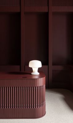 a white object on top of a wooden table in a room with red walls and shelves