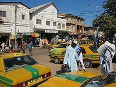 people are walking through the busy street in front of taxi cabs