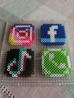 four pieces of bead art sitting on top of a table