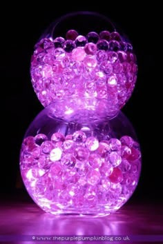 two glass balls with lights on them in the dark, one is filled with bubbles