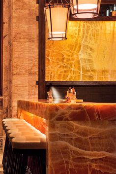 the interior of a restaurant with marble counter tops and lights hanging from the ceiling above