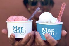 two people holding up ice creams in their hands