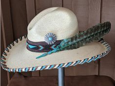 The Thunderbird starts with a Mexican soft palm Gus hat body that has a 4" brim and 5 1/2" crown. Hand laced in three colors of leather lace - chocolate brown, turquoise and saddle. The beaded hatband has a thunderbird pattern and is mounted on chocolate suede. The back of the band has a deer antler bead for accent. Large antiqued Concho with a faux turquoise stone. A massive barred turkey feather dyed in turquoise completes the hat. All hats are made to order. Allow up to 4 weeks for your hat t Feather Hat Band, Beaded Feathers, Antler Beads, Jordan Hats, Couture Hats, Rancher Hat, Painted Hats, Hat Holder