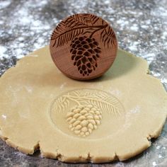 a cookie with a wooden stamp on top of it and some grapes in the middle