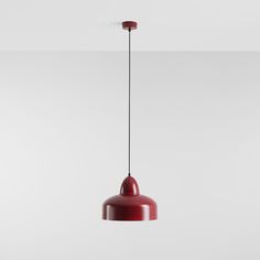 a red pendant light hanging from a ceiling