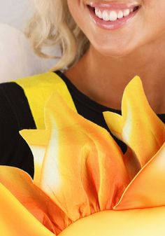 a close up of a woman holding a banana with flowers on it's side