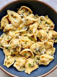 a blue bowl filled with pasta covered in sauce