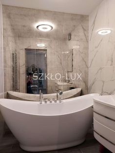 a large white bath tub sitting inside of a bathroom