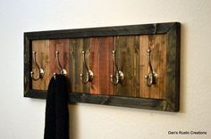 a coat rack made out of wood and metal hooks