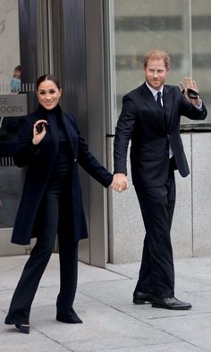 prince harry and his wife, the duke of cambridge, hold hands as they walk outside an office building