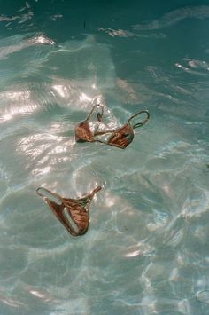 two pairs of sandals floating in the water