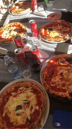 several pizzas are on the table ready to be eaten at an outdoor restaurant or gathering