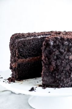 a chocolate cake on a white plate with one slice cut out