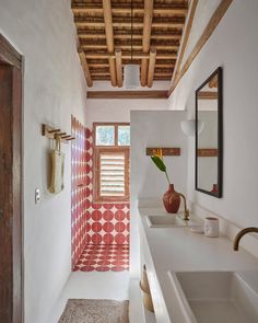 a bathroom with red and white patterned shower curtain