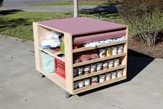 an outdoor storage unit with lots of food on it's shelves and bins