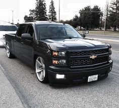 the black truck is parked on the side of the road