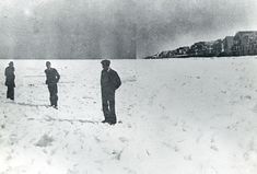 black and white photograph of men standing in the snow