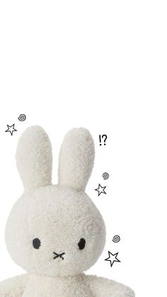 a white stuffed rabbit sitting on top of a table next to stars and confetti