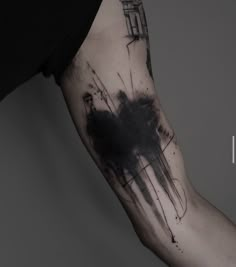 a black and white photo of a person's arm with ink splattered on it