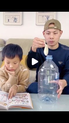 two boys are sitting on a couch and one boy is holding a spoon