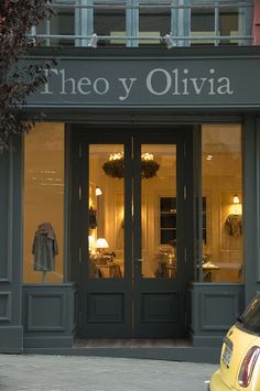 a yellow car is parked in front of the entrance to an italian restaurant, called theo y olivia