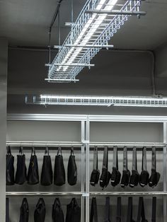 a rack with many bags hanging from it's sides and some lights above them