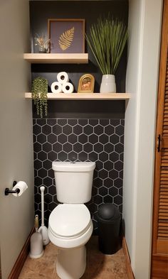 a white toilet sitting in a bathroom next to a shelf