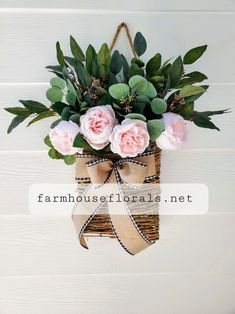 pink flowers in a burlock hanging from a door with the words farmhouse florals net above it