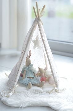 a teepee tent with two stuffed animals in it and stars on the top of it