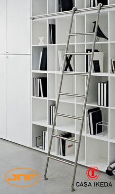 a ladder leaning against a white bookcase filled with books