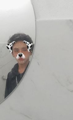 a mirror with a dog's face reflected in it and the reflection of a person wearing dalmatian hair