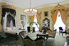 a living room filled with lots of furniture next to a window covered in drapes