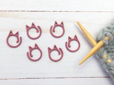 cat shaped cookie cutters sitting next to a knitting needle