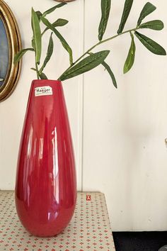 a red vase sitting on top of a table