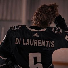 the back of a hockey player's jersey with his hands on his head,