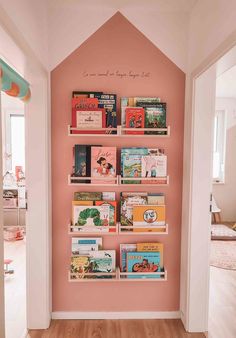 there is a pink wall with books on it