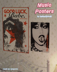 two posters are hanging on the wall above a bed