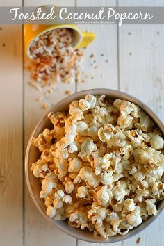 a bowl filled with popcorn sitting on top of a wooden table