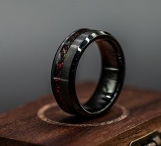 Get ready to enrich your wedding band selection with this Bold and Rustic Wedding Ring. It is a piece of Black brushed tungsten that is carefully milled. We also added a channel of black fire opal. This ring exudes strength, durability, and a modern elegance. **Quality Assurance**We take pride in providing our customers with the highest quality products. Each ring is carefully crafted by skilled artisans and undergoes rigorous quality checks to ensure that it meets our stringent standards. We us Black Opal Mens Ring, Rustic Wedding Ring, Black Fire Opal, Rustic Wedding Rings, Opal Band, Fire Opal Ring, Cushion Ring, Black Fire, Ring Mens