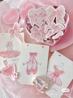 some cards with pink designs on them sitting next to a heart shaped box and other items