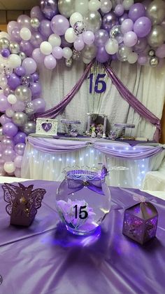 purple and white balloons are hanging over a table at a ballon themed birthday party