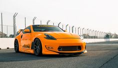 an orange sports car driving on a race track