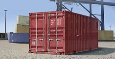 a large red container sitting on top of a sandy beach next to a metal structure