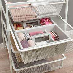 an organized drawer is shown with folded towels and other items in the bins for storage