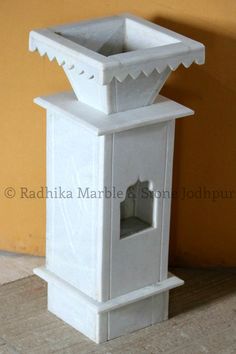 a white vase sitting on top of a tiled floor