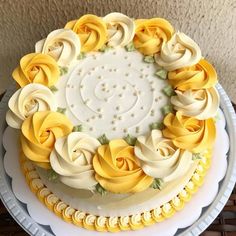 a white cake with yellow frosting roses on it