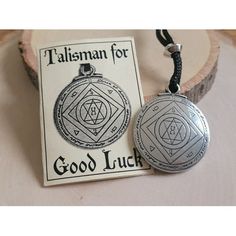 two pendants with the words good luck and an image of a seal on it